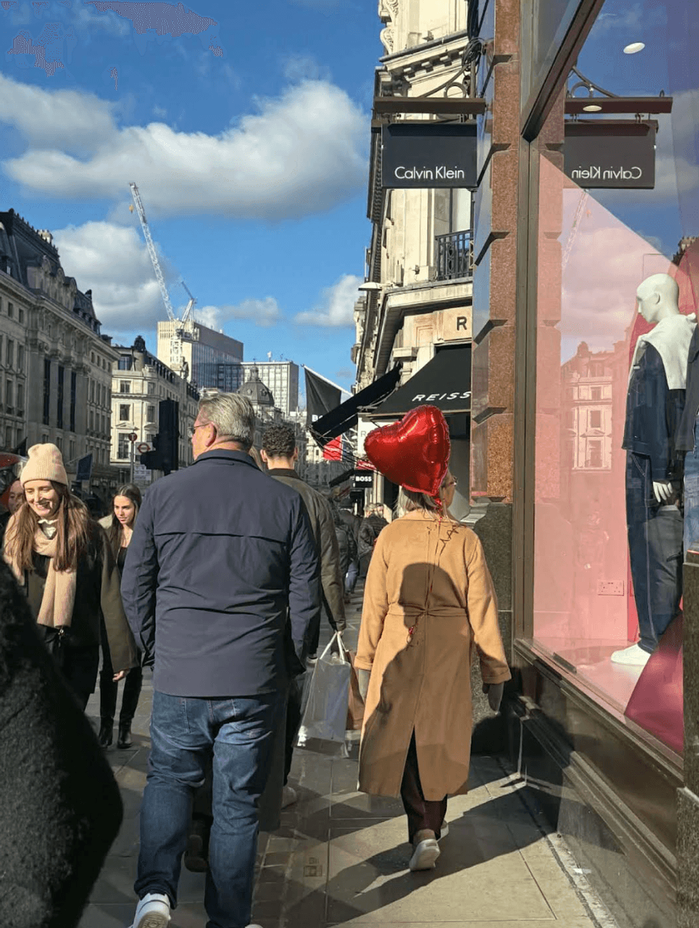 \u200bPeople walking on a sidewalk.