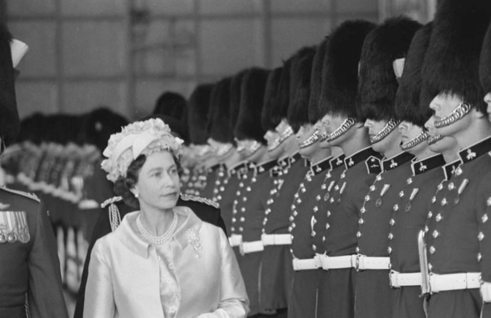 \u200bQueen Elizabeth II stands beside the Governor General\u2019s Foot Guards.