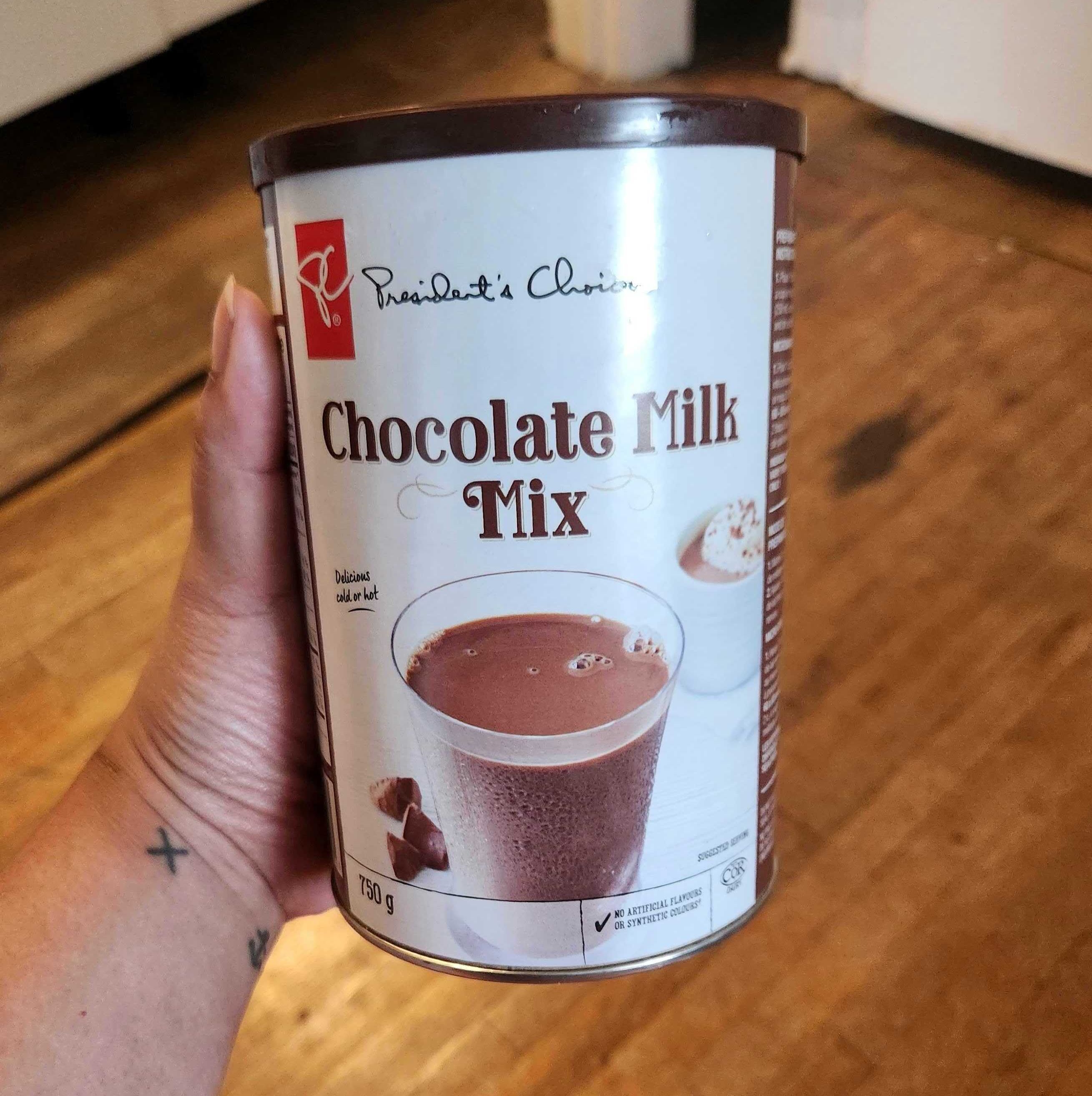 \u200bSarah holding a tin of President's Choice brand hot chocolate mix from Loblaws, 750 grams for $5.49.
