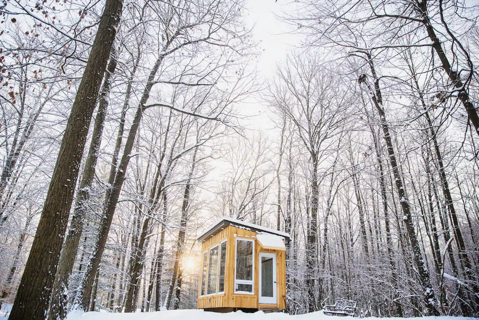 \u200bTiny cabin in a snowy woodland.