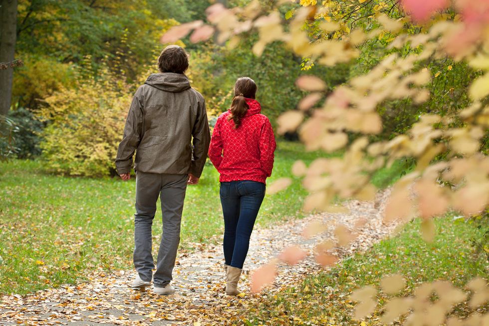 \u200bTwo people walking on a trail in a park.