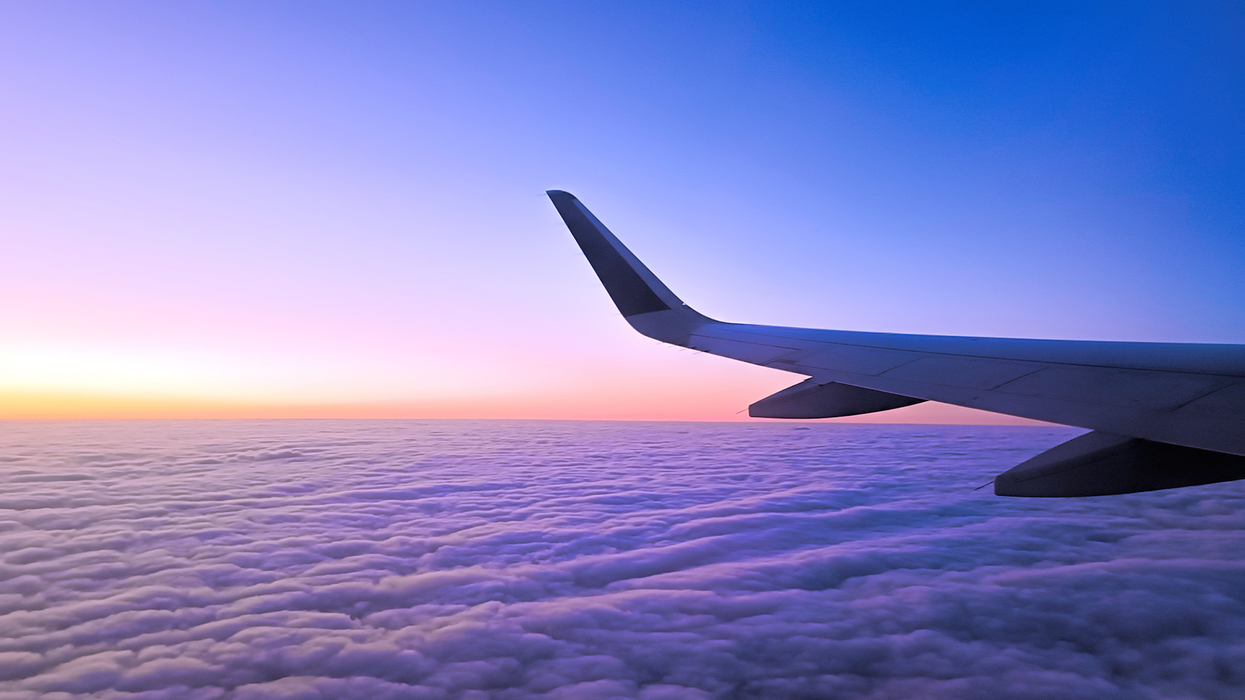 Un aileron dans un ciel bleu et mauve au-dessus des nuages.