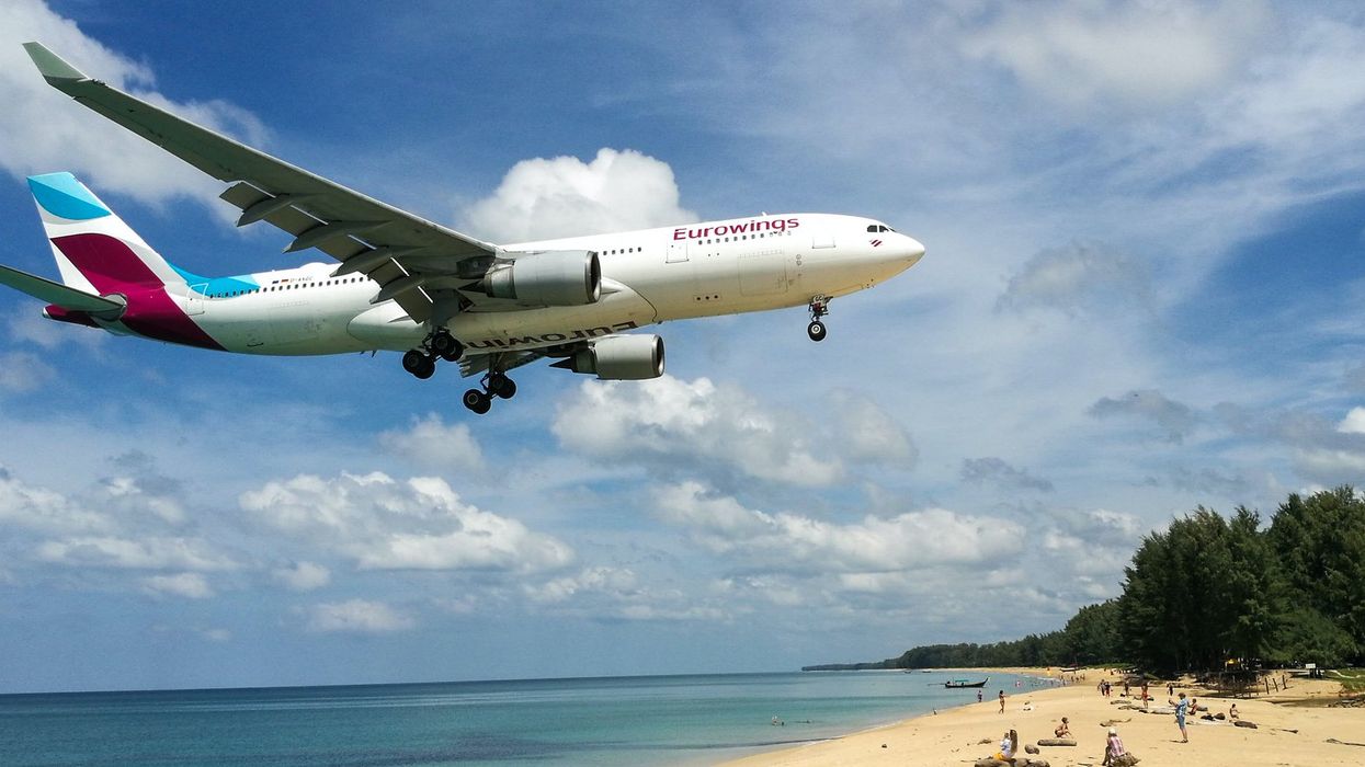 Un avion Eurowings qui survole une plage.