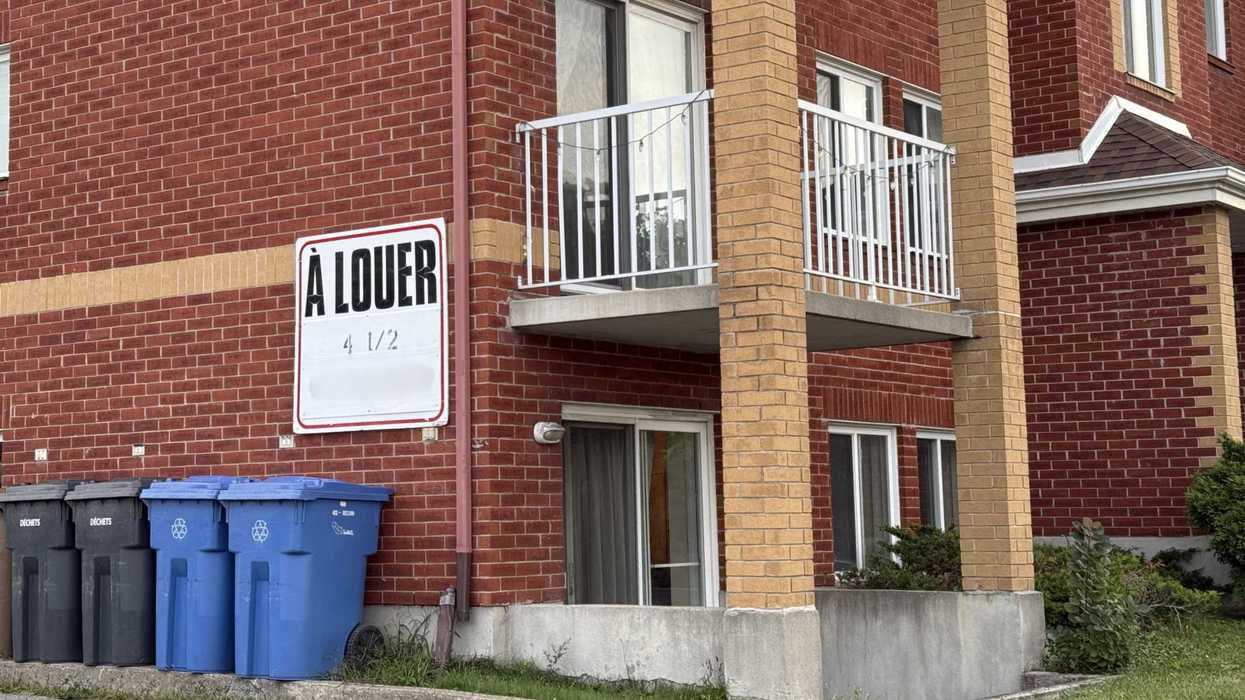 Un bloc d'appartements et une affiche « À louer ».