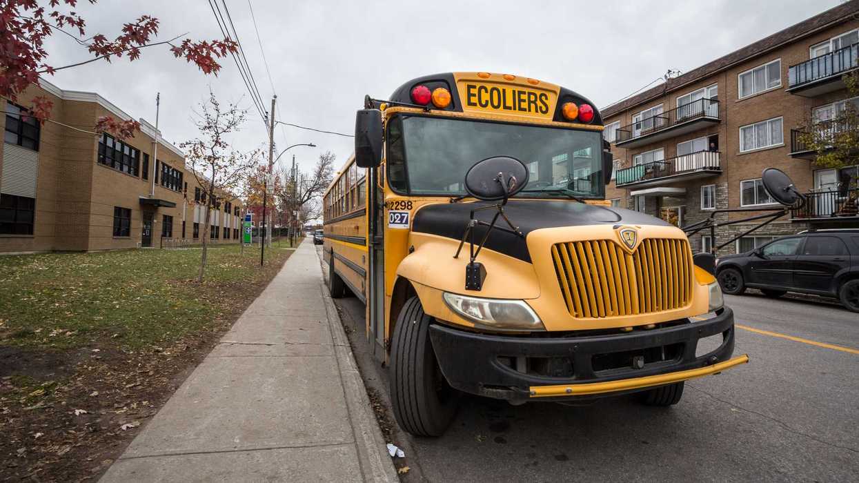 Un bus scolaire devant une école.