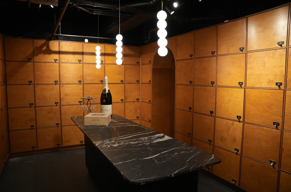 Un cellier avec une table et une grosse bouteille de vin sur le dessus.