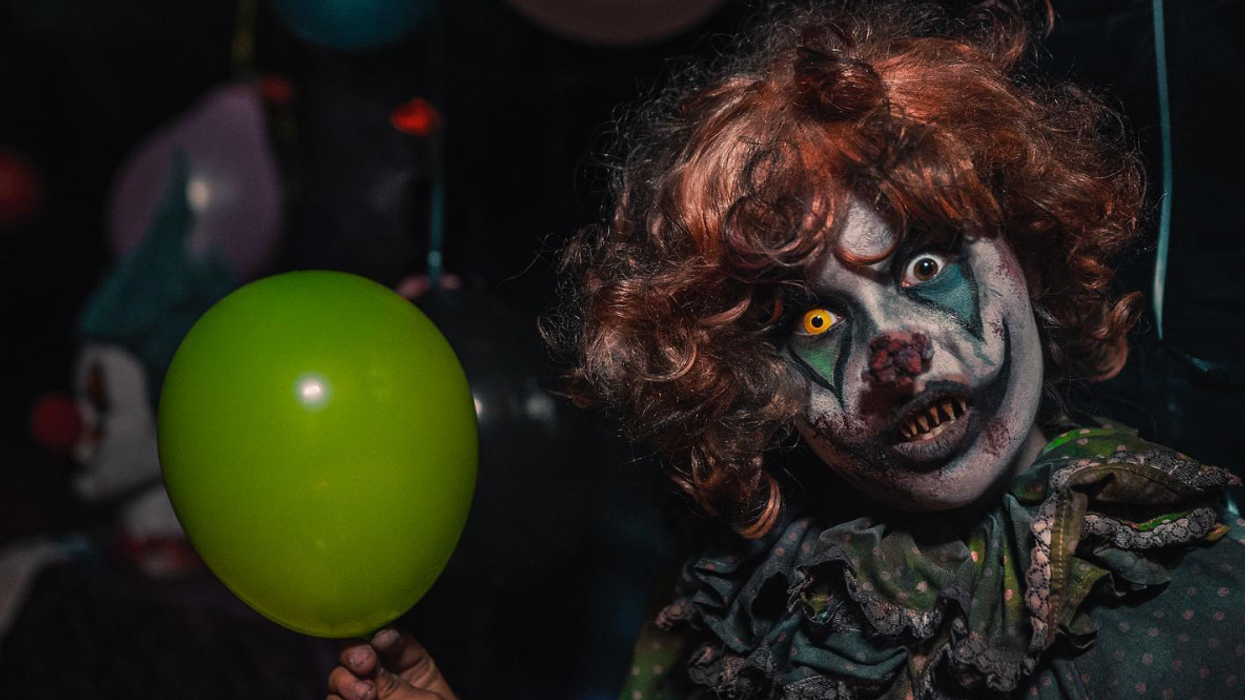 Un clown effrayant qui tient une baloune.