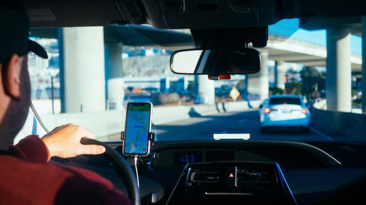 Un conducteur Uber dans son véhicule suit les directions de son GPS sur la route.