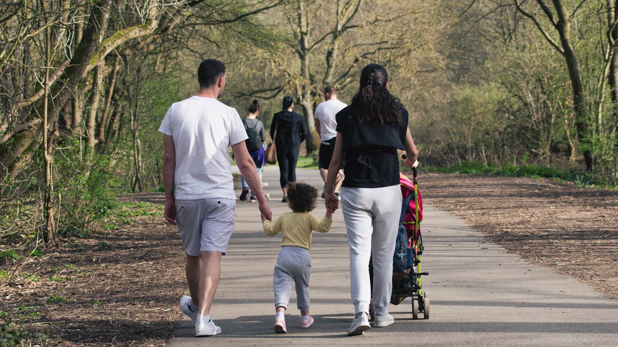 Un couple et leur enfant en forêt.