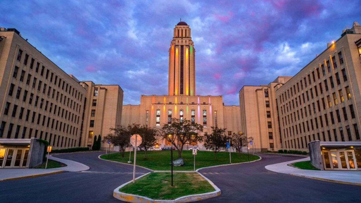 Un des bâtiments principaux de l'Université de Montréal est illuminé le soir.