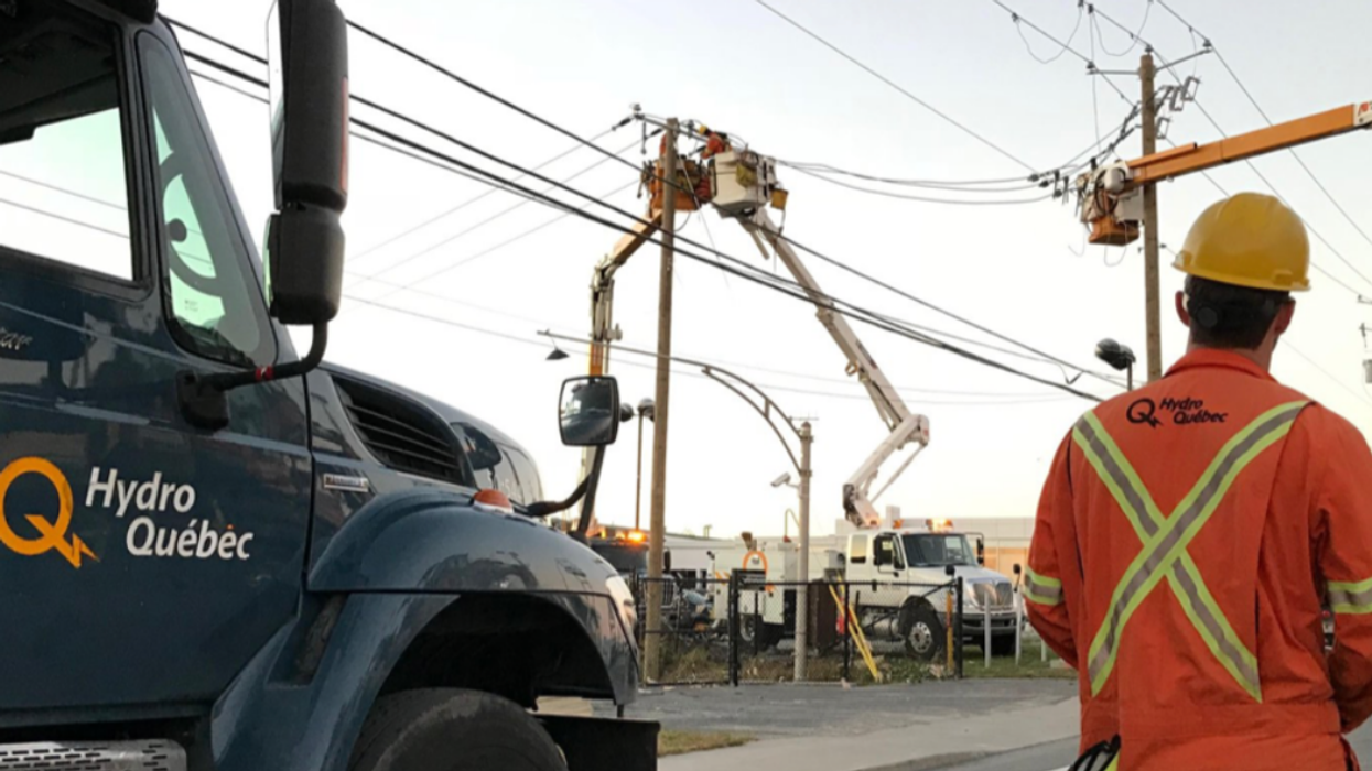 Un employé de l'entreprise Hydro-Québec debout à côté d'un camion.
