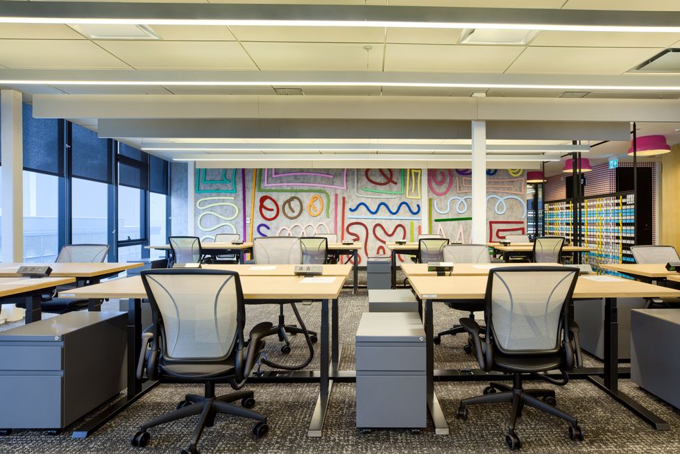 Un espace de bureau ouvert avec un mur o\u00f9 il y a des formes color\u00e9es.