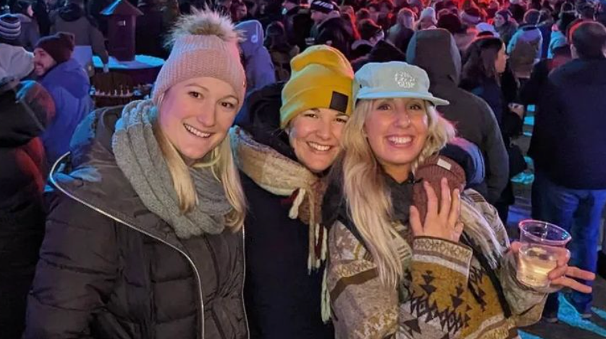 Un groupe de trois personnes en vêtement d'hiver au Quartier des spectacles.