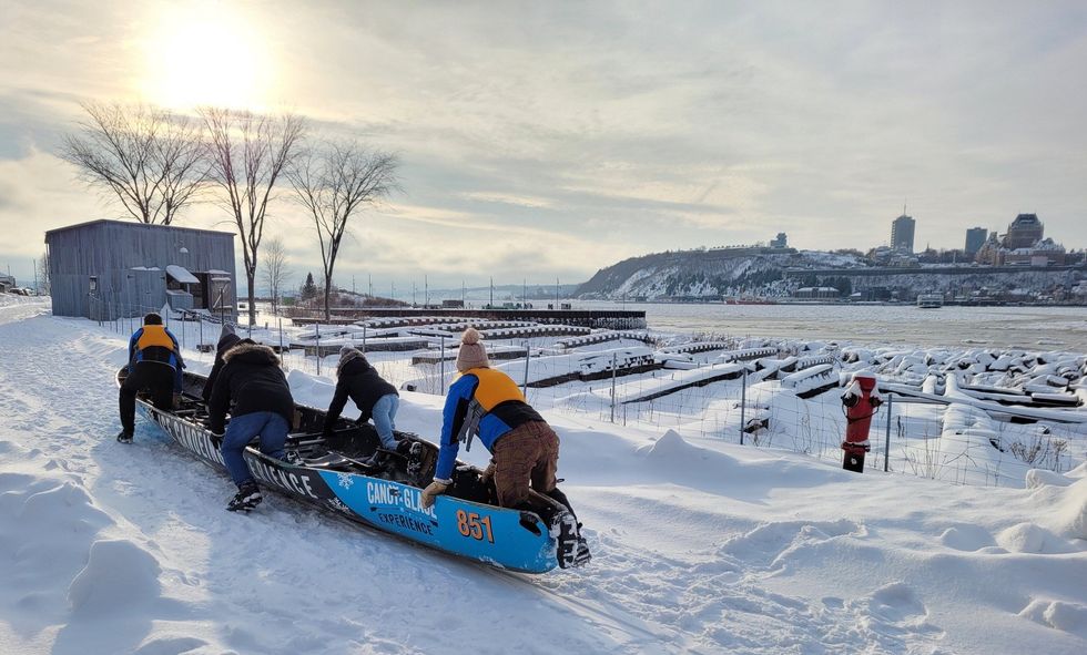 Un groupe faisant du canot sur glace devant le fleuve \u00e0 L\u00e9vis au Qu\u00e9bec.