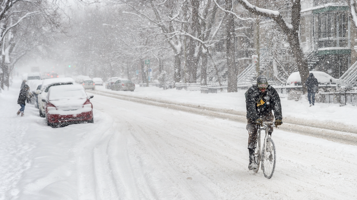 Un homme à vélo dans la neige au Québec.