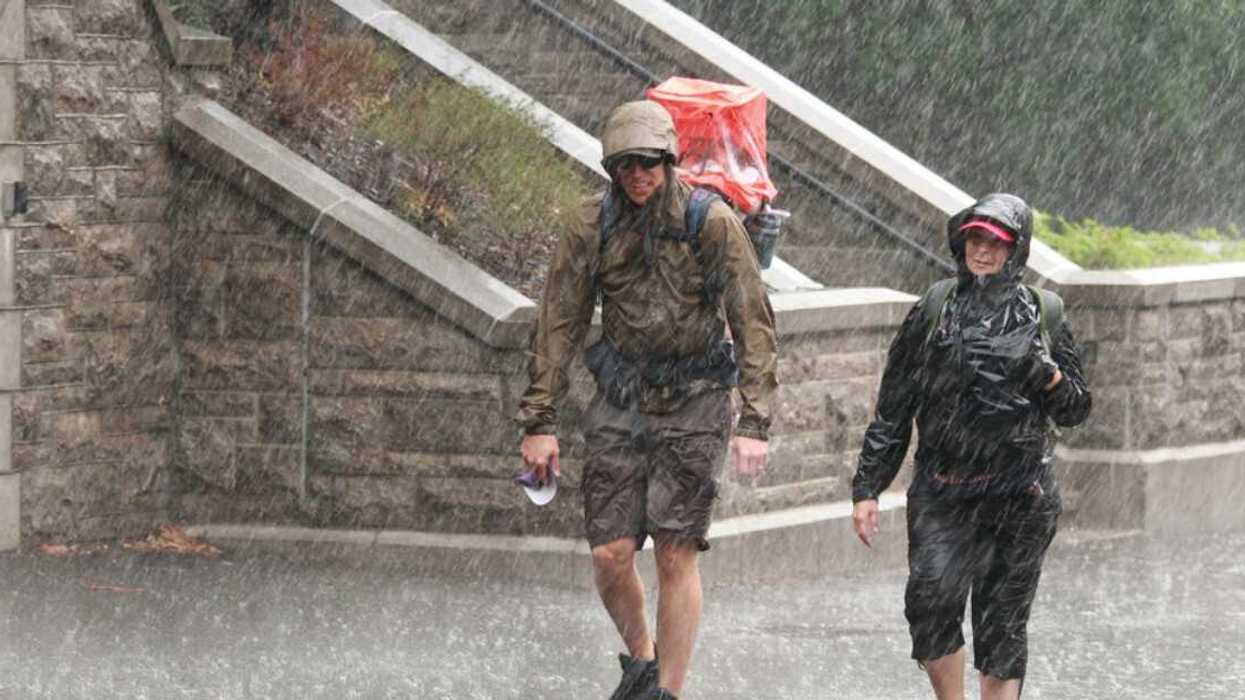 Un homme et une femme marchant sous une forte pluie.