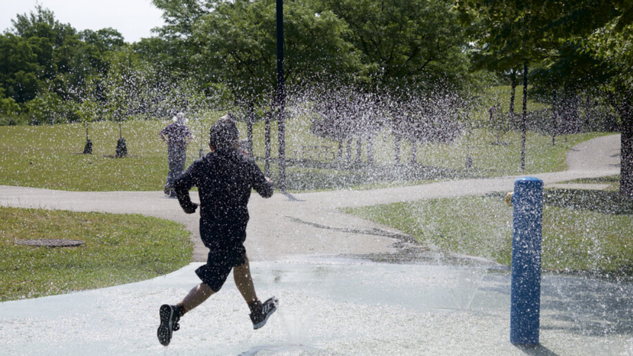 Un homme fait son jogging sous des jets d'eau.