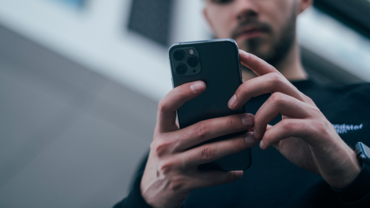 Un homme regarde le téléphone cellulaire dans sa main.