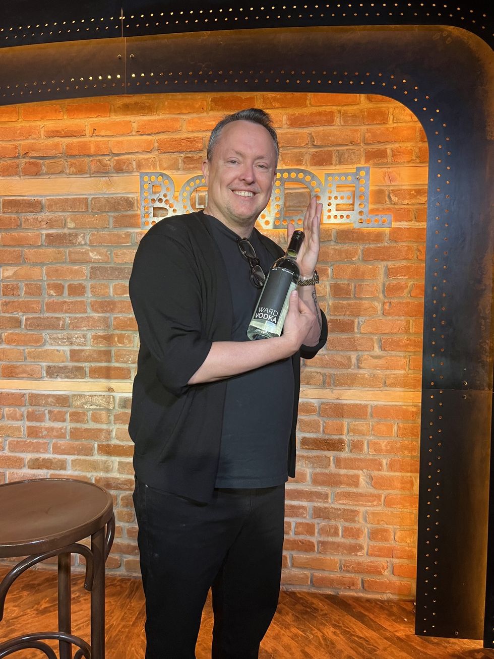 Un homme tient une bouteille de vodka entre ses mains.