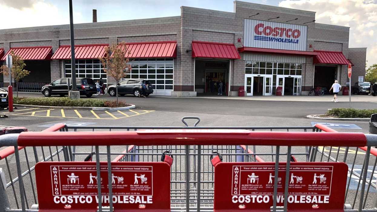 Un panier d'épicerie Costco devant un entrepôt.