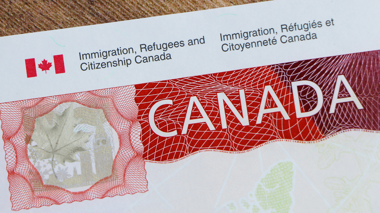 Un papier sur lequel il est inscrit Immigration, Réfugiés et Citoyenneté Canada avec CANADA en grosses lettres sur un fond rouge.
