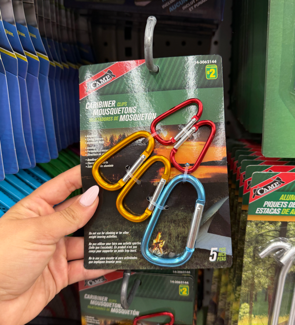 Un paquet de cinq mousquetons de couleurs vives tenu \u00e0 la main.