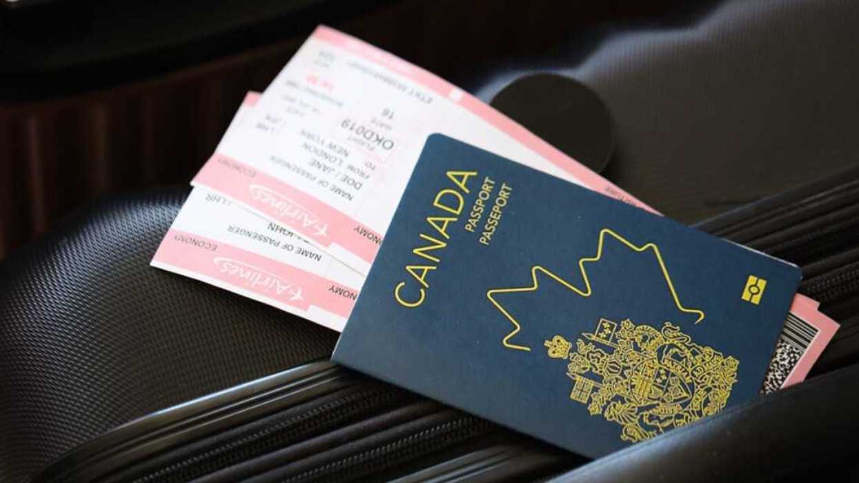 Un passeport canadien avec des cartes d'embarquement déposé sur une valise.