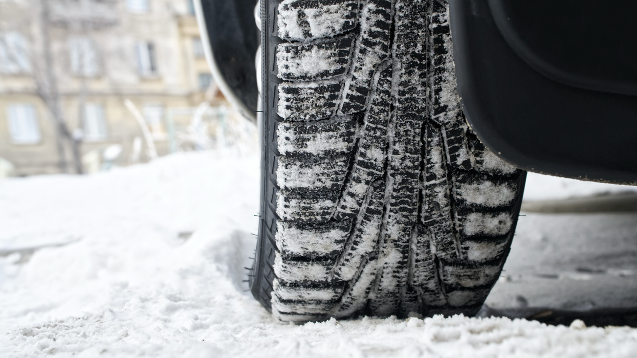 Un pneu d'hiver vu de près dans la neige.