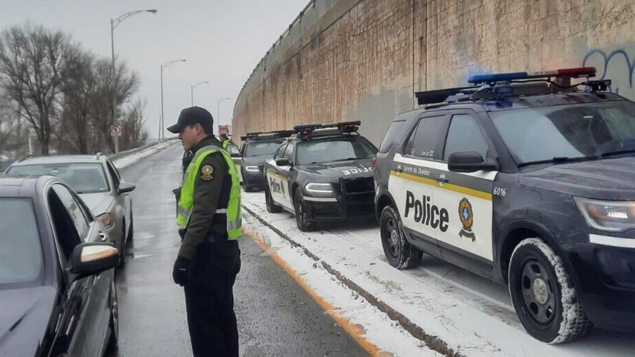 Un policier de la Sûreté du Québec intervenant auprès d'automobilistes.