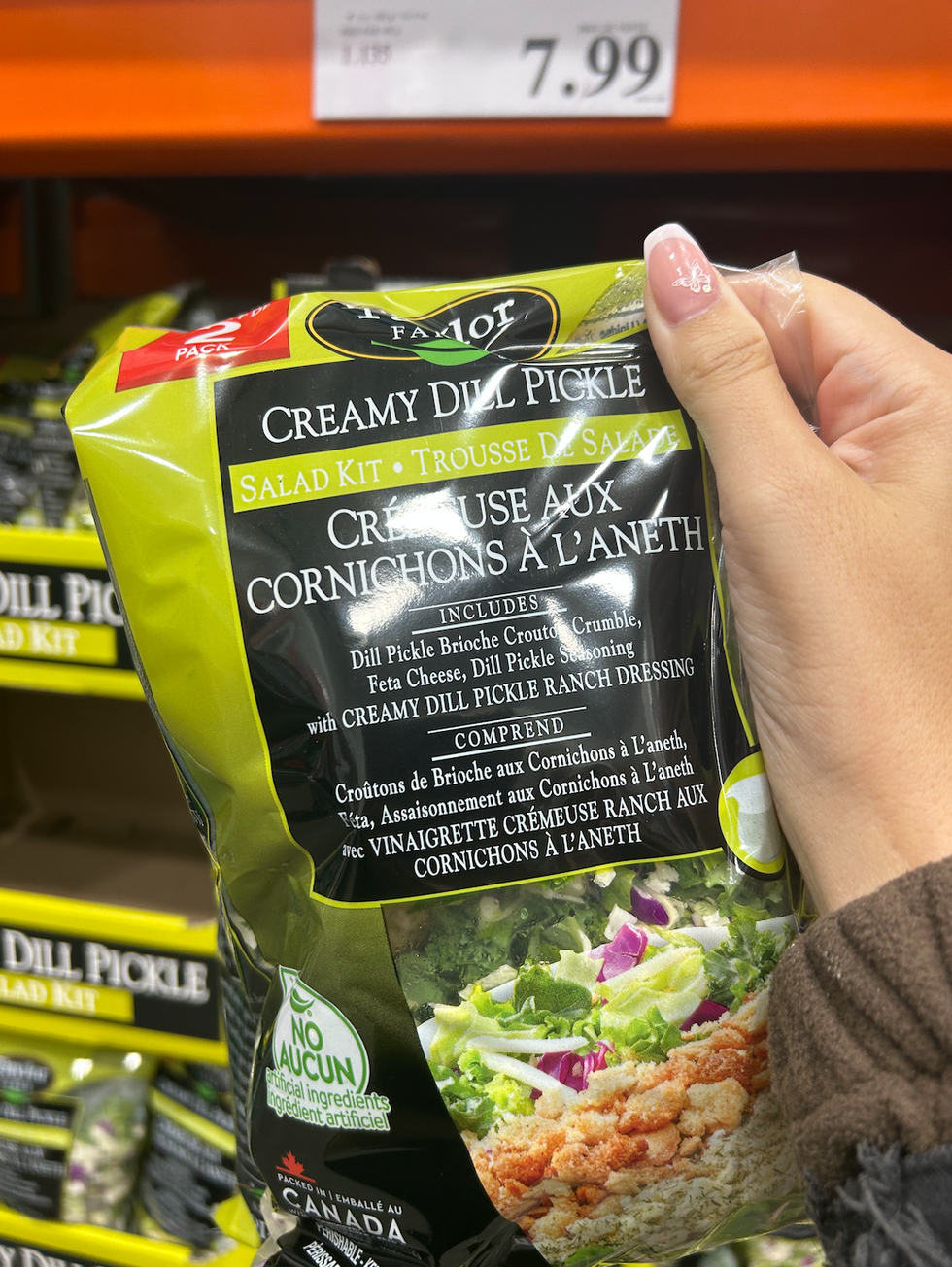 Un sac de salade cr\u00e9meuse aux cornichons \u00e0 l'aneth devant un pr\u00e9sentoir du Costco.