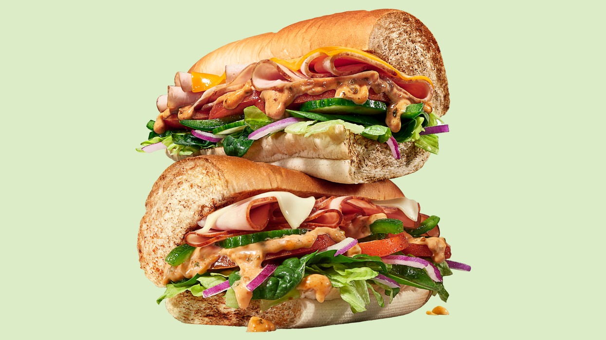 Un sandwich Subway préparé avec la nouvelle sauce Mojo sur un fond vert.
