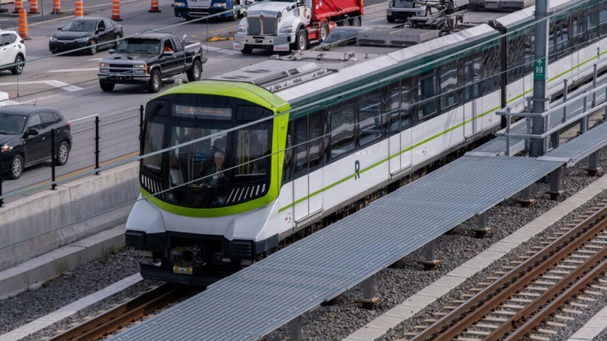 Un train du REM circule sur les rails près de l'autoroute entre Brossard et Montréal.