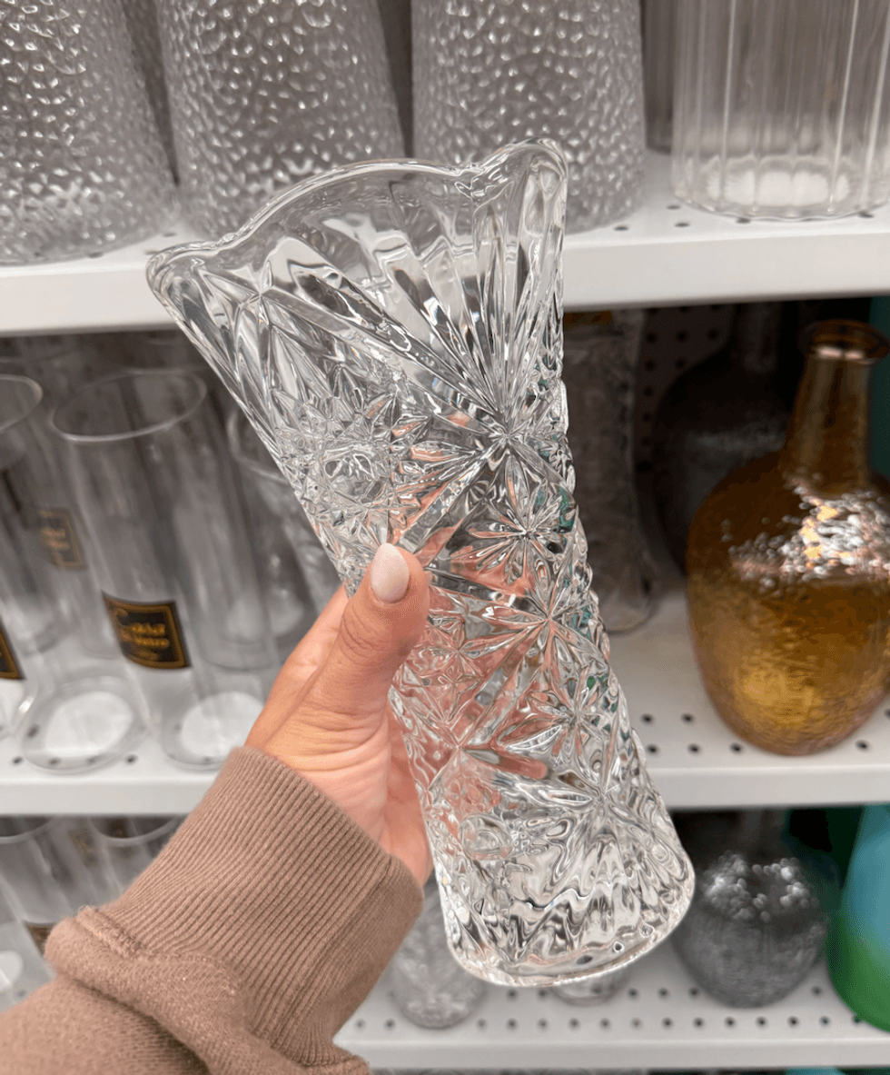 Un vase en verre dans une main au Dollarama.