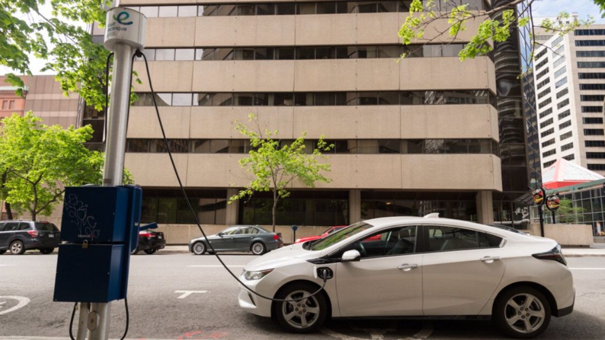 Un véhicule électrique blanc est branché sur une borne de recharge du Circuit Électrique à Montréal.