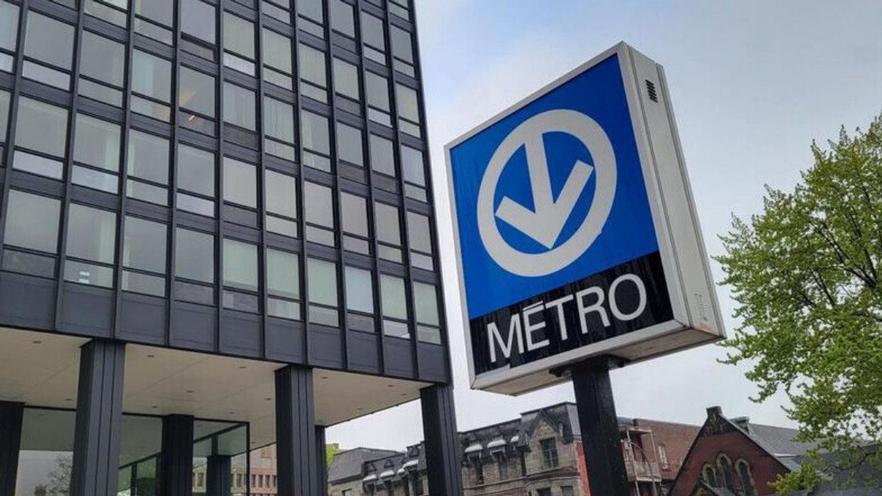 Une affiche du métro de Montréal devant un immeuble.