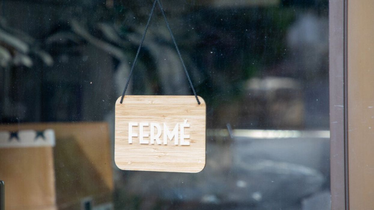 Une affiche où il est inscrit FERMÉ dans une vitrine.