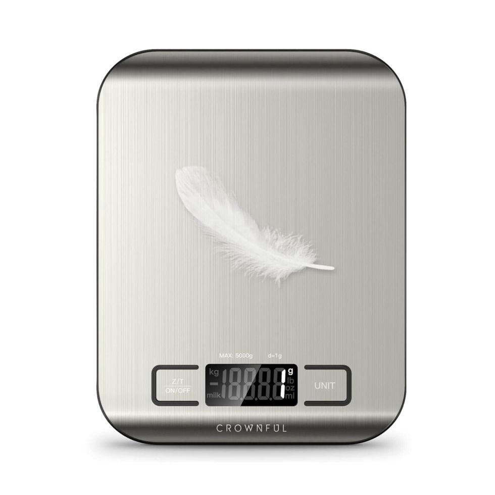 Une balance alimentaire en acier inoxydable sur fond blanc.