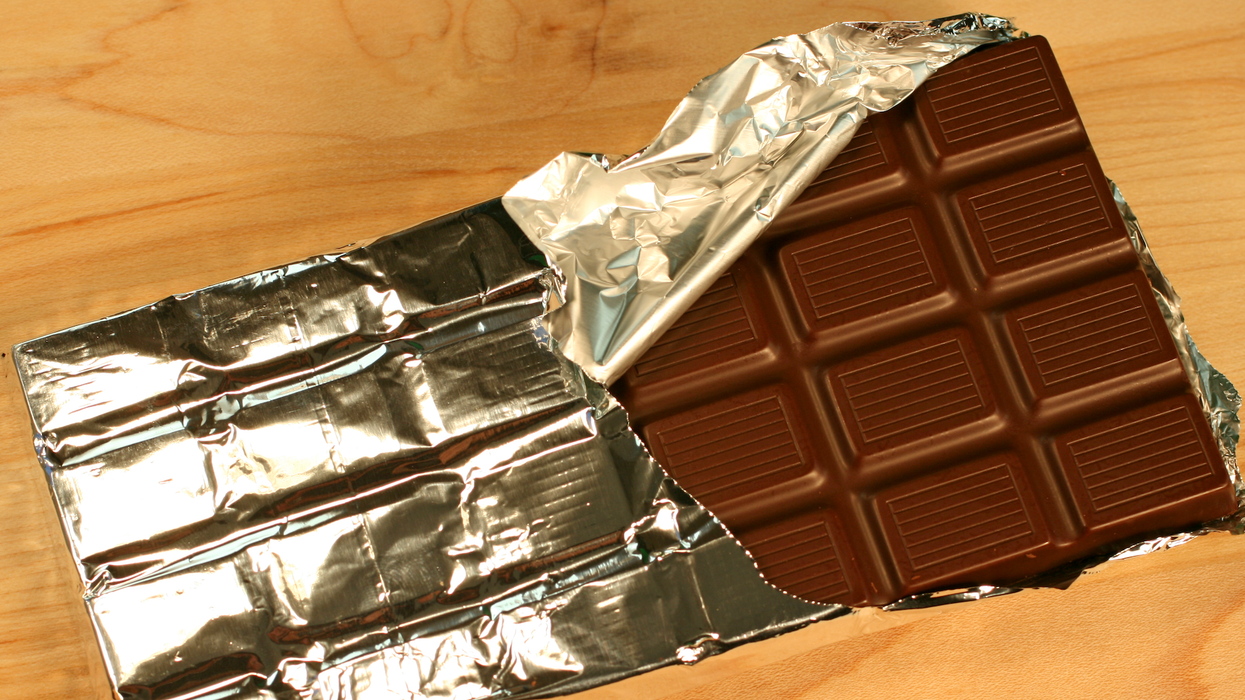 Une barre de chocolat recouverte partiellement d'un emballage en aluminium.