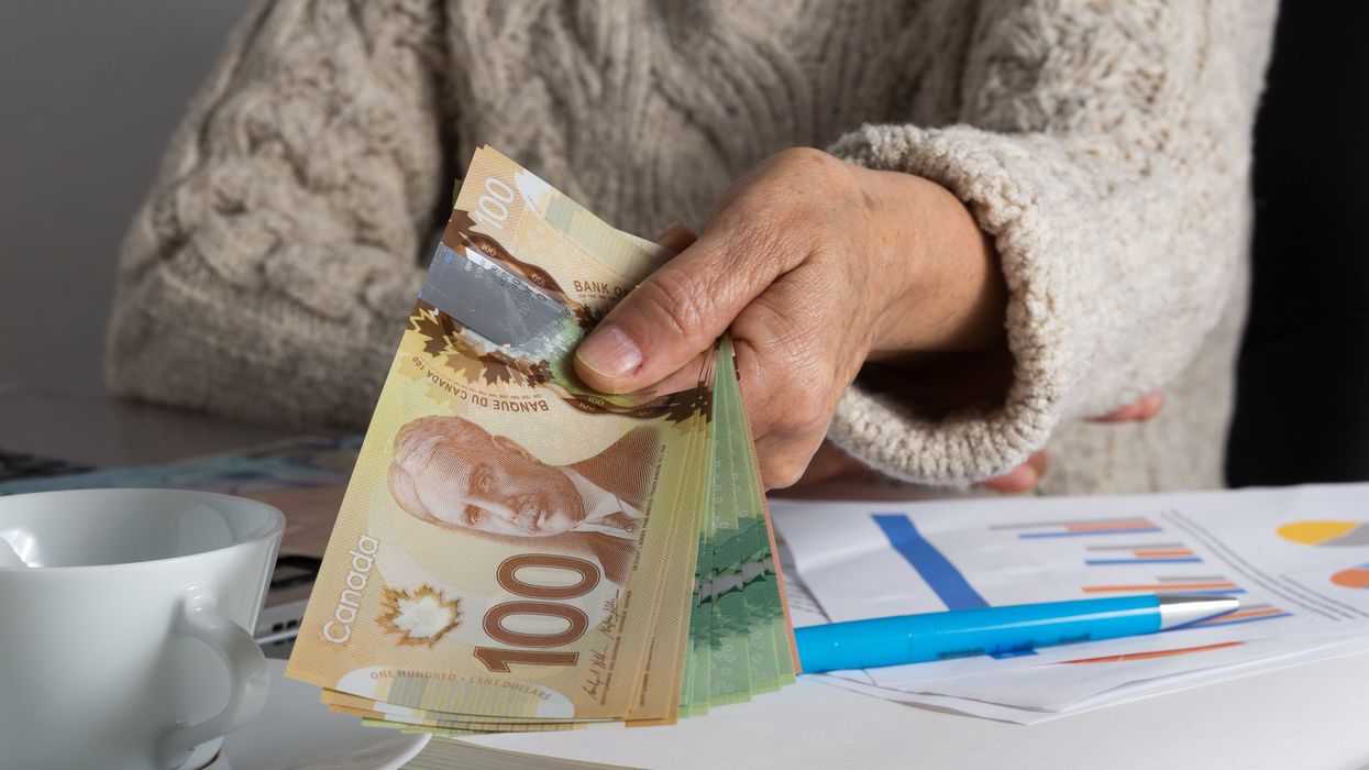 Une dame qui tient de l'argent canadien.