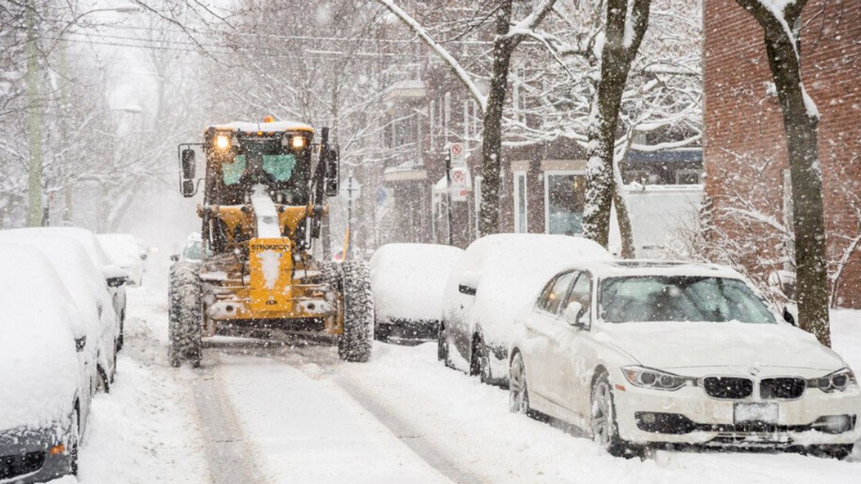 Une déneigeuse à l'oeuvre dans une rue enneigée à Montréal.