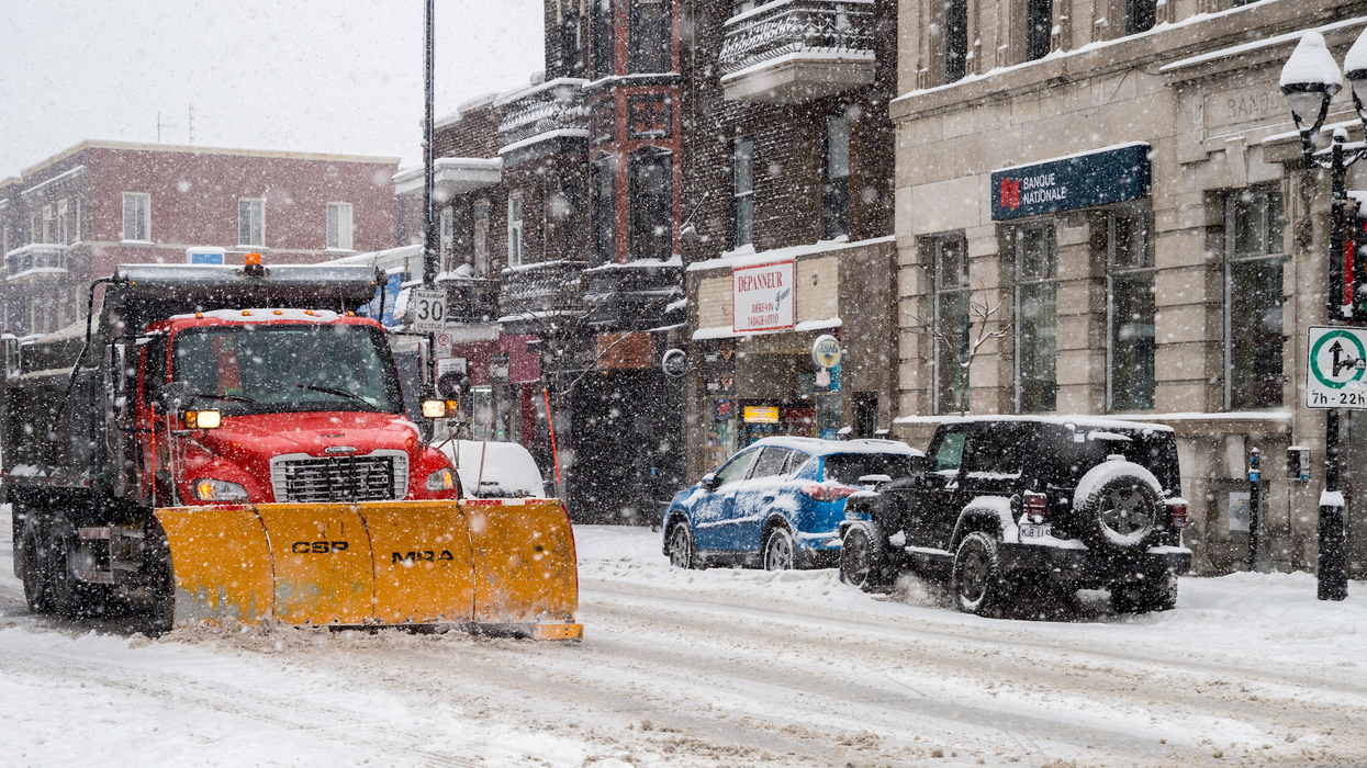 Une déneigeuse circule dans une rue enneigée à Montréal.