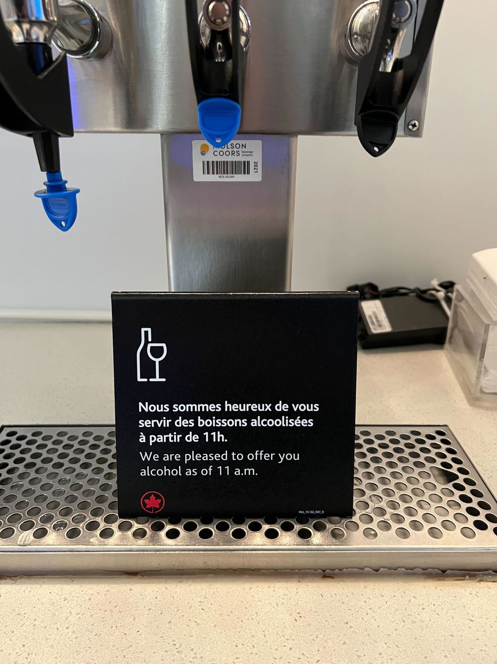 Une enseigne plac\u00e9e sur un distributeur de bi\u00e8re indique qu'aucun alcool n'est servi avant 11 h du matin.