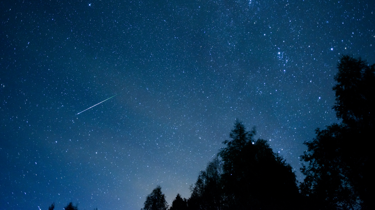 Une étoile filante dans un ciel bleu étoilé.