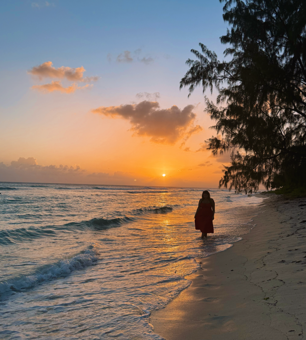 Une femme marche sur la plage en Barbade dans les Cara\u00efbes.