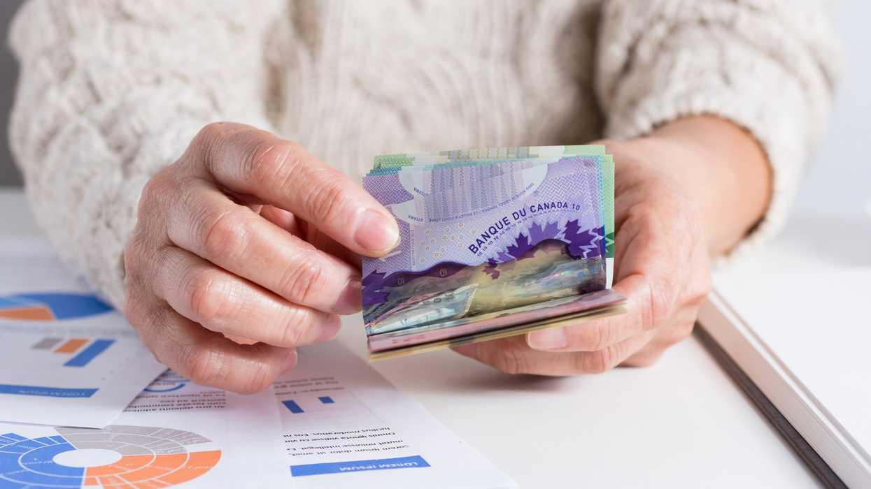 Une femme qui compte de l'argent canadien.