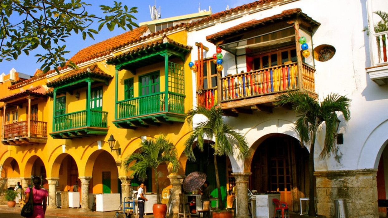 Une femme se promène devant les bâtiments colorés à Carthagène, en Colombie.