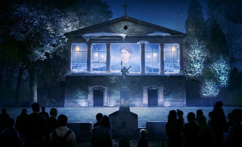 Une foule devant une projection lumineuse dans le cimeti\u00e8re.