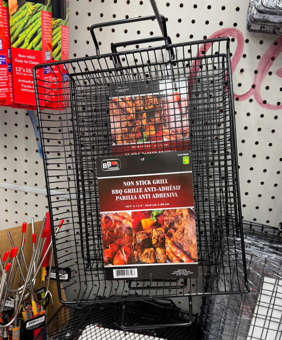 Une grille noire rectangulaire \u00e0 poign\u00e9e, emball\u00e9e avec des images de viandes grill\u00e9es.