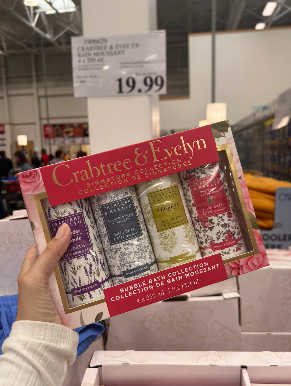 Une main tenant la collection de bain moussant Crabtree & Evelyn au Costco.