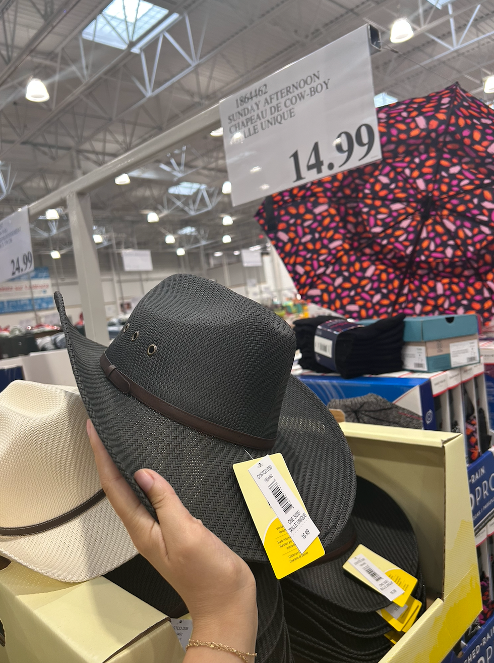 Une main tenant un chapeau de cowboy noir au Costco.